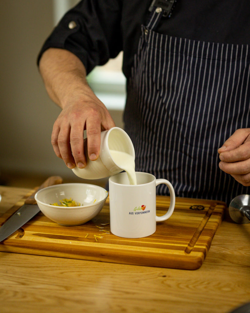 Loewenzahnblueten mit Milch mischen